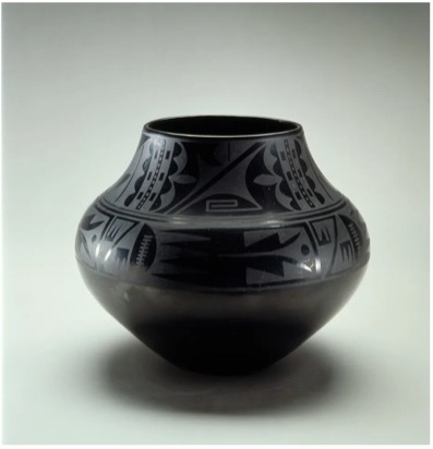 A black vase with geometric shapes carved into the surface.